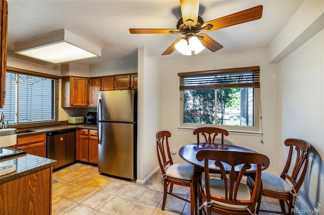 kitchen with appliances with stainless steel finishes, dark countertops, plenty of natural light, and brown cabinets
