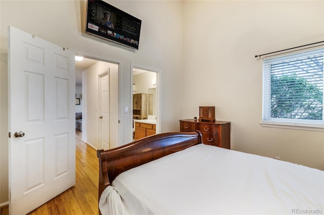 bedroom featuring light wood-style floors and connected bathroom