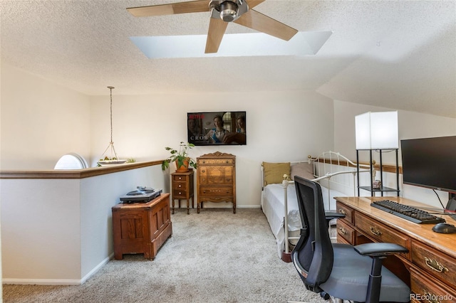 office featuring a ceiling fan, light colored carpet, a textured ceiling, a skylight, and baseboards