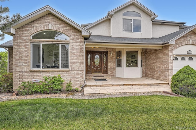 6335 Oberon Rd, Arvada, CO 80004 - view of front of property featuring brick siding, stucco siding, and a front lawn