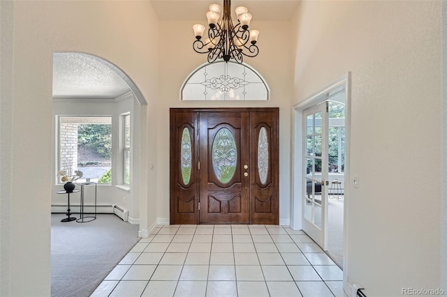 6335 Oberon Rd, Arvada, CO 80004 - foyer featuring arched walkways, light carpet, a chandelier, a baseboard heating unit, and baseboards