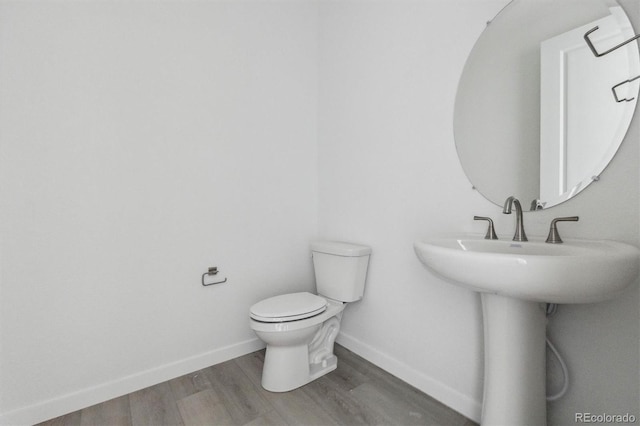 25234 E Warren Pl, Aurora, CO 80018 - half bathroom featuring wood finished floors, toilet, and baseboards