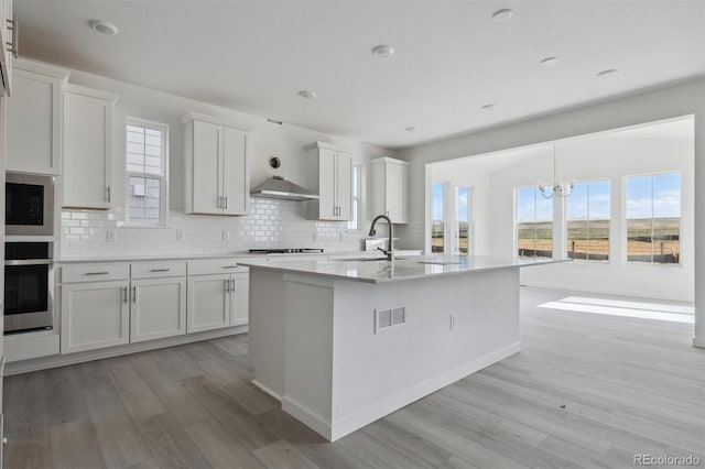 25234 E Warren Pl, Aurora, CO 80018 - kitchen featuring stainless steel appliances, light wood-type flooring, backsplash, a sink, and a chandelier