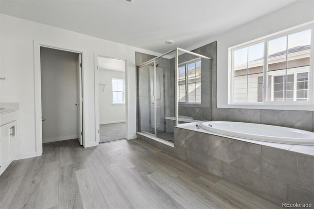 25234 E Warren Pl, Aurora, CO 80018 - full bath featuring wood finished floors, a garden tub, a shower stall, and vanity