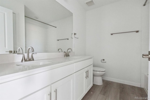25234 E Warren Pl, Aurora, CO 80018 - full bath with toilet, double vanity, wood finished floors, and baseboards