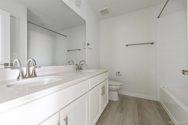 25234 E Warren Pl, Aurora, CO 80018 - bathroom with toilet, wood finished floors, double vanity, shower / bath combination, and baseboards
