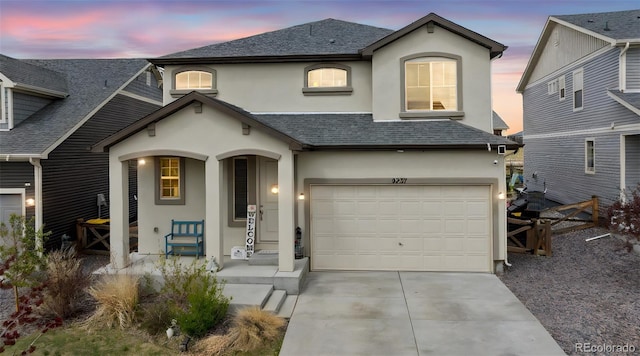 view of front of home featuring an attached garage, stucco siding, covered porch, and driveway