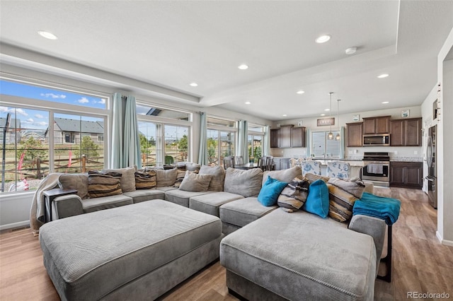 living area with recessed lighting, baseboards, and light wood finished floors