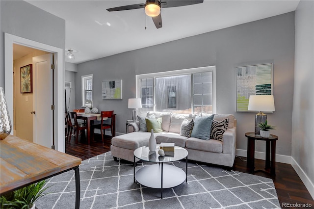 living room featuring ceiling fan and dark hardwood / wood-style floors