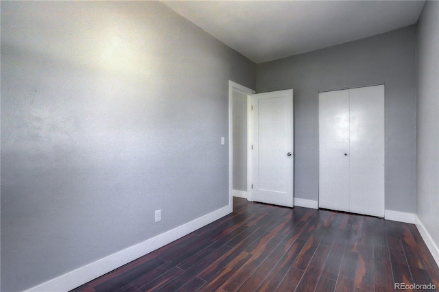 unfurnished bedroom with a closet and dark hardwood / wood-style floors