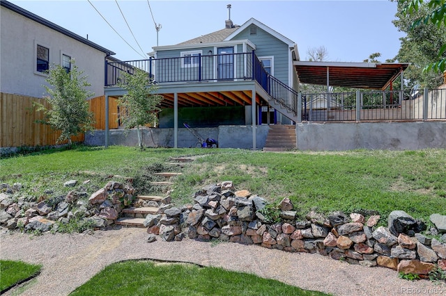 rear view of property with a lawn and a wooden deck