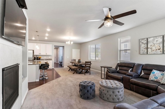 living room featuring dark hardwood / wood-style flooring and ceiling fan with notable chandelier