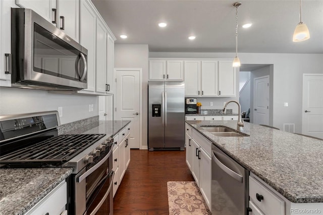 kitchen with a kitchen island with sink, sink, dark hardwood / wood-style floors, white cabinetry, and stainless steel appliances