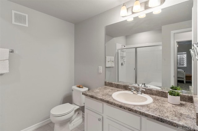 bathroom with tile patterned flooring, vanity, a shower with door, and toilet