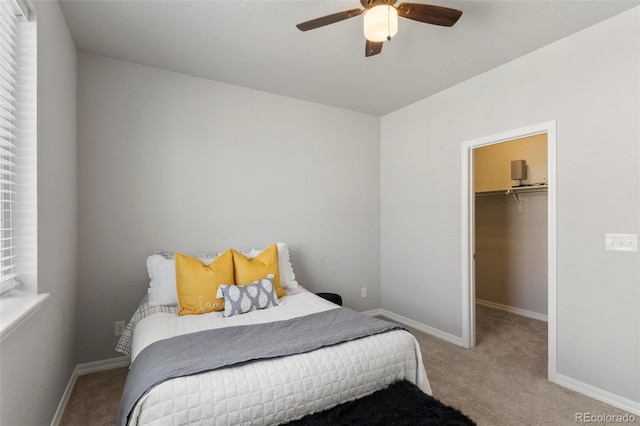 carpeted bedroom featuring ceiling fan, a spacious closet, and a closet