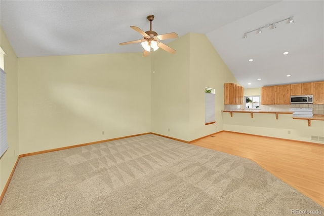 1624 Daphne St, Broomfield, CO 80020 - unfurnished living room with light colored carpet, ceiling fan, high vaulted ceiling, and recessed lighting