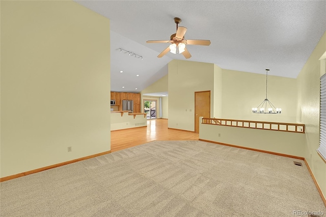 1624 Daphne St, Broomfield, CO 80020 - spare room with light carpet, vaulted ceiling, a ceiling fan, and a chandelier