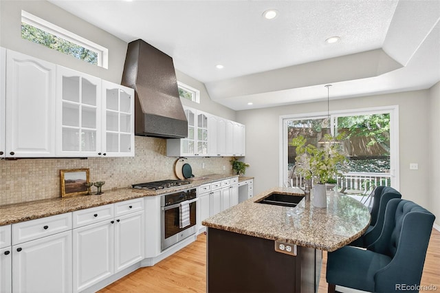 4501 Whitehall Ln, Highlands Ranch, CO 80126 - kitchen with appliances with stainless steel finishes, custom range hood, light wood-type flooring, decorative backsplash, and recessed lighting