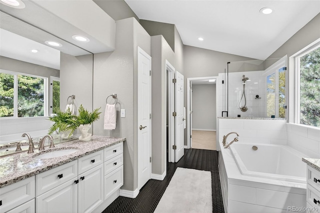 4501 Whitehall Ln, Highlands Ranch, CO 80126 - full bath with vanity, a bath, tiled shower, recessed lighting, and vaulted ceiling