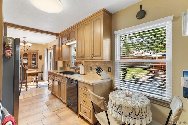 1317 E Uintah St, Colorado Springs, CO 80909 - kitchen with black dishwasher, a sink, freestanding refrigerator, light countertops, and tasteful backsplash