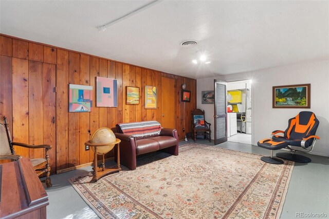 1317 E Uintah St, Colorado Springs, CO 80909 - living room with finished concrete flooring, electric panel, and wooden walls