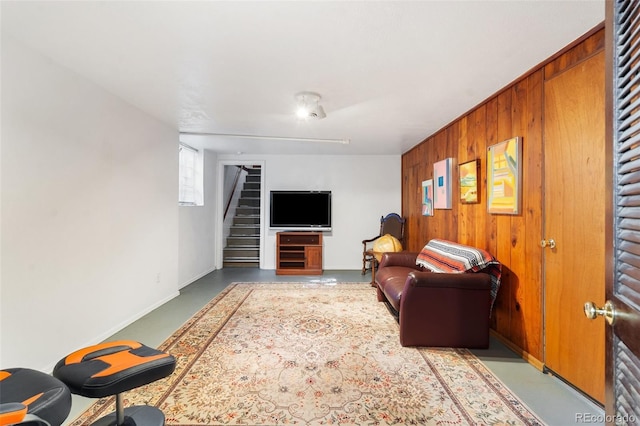 1317 E Uintah St, Colorado Springs, CO 80909 - living area featuring stairway, wood walls, concrete floors, and baseboards