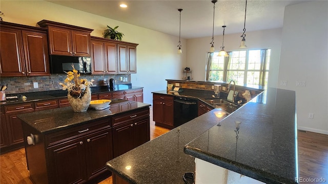 kitchen featuring light wood-type flooring, a large island, a sink, backsplash, and dishwasher