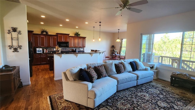 living area with baseboards, dark wood finished floors, a ceiling fan, and recessed lighting