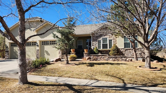 view of front facade with stucco siding, an attached garage, stone siding, driveway, and a front lawn