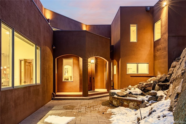 exterior entry at dusk with a patio area