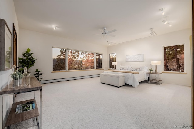 carpeted bedroom featuring ceiling fan and a baseboard heating unit