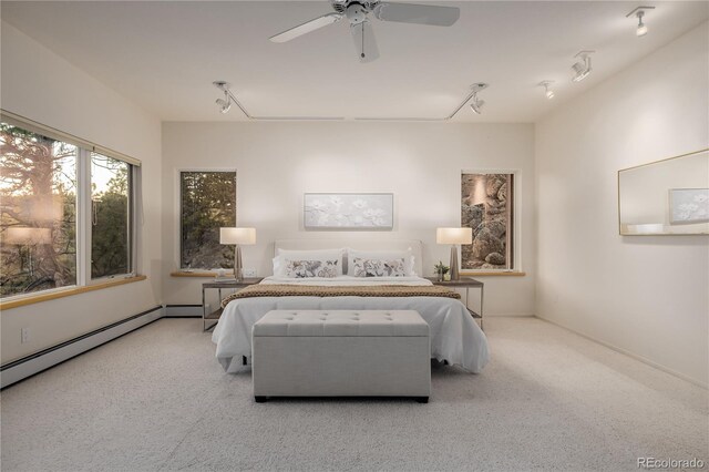 carpeted bedroom featuring ceiling fan and a baseboard heating unit