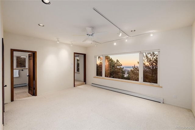 carpeted empty room with ceiling fan and baseboard heating