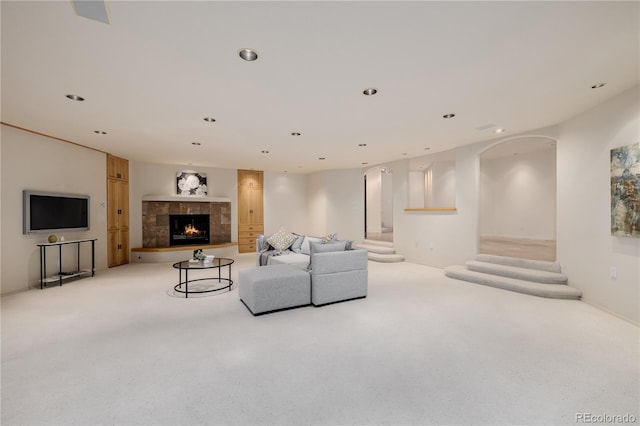 carpeted living room with a tiled fireplace