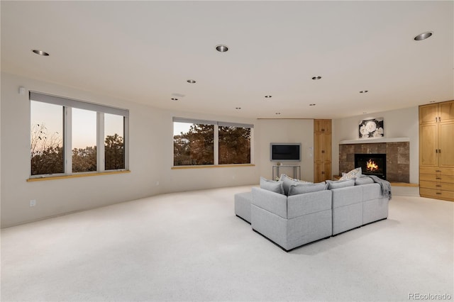 carpeted living room with a tiled fireplace