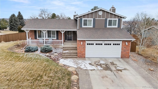 split level home featuring a garage, a shingled roof, concrete driveway, covered porch, and brick siding