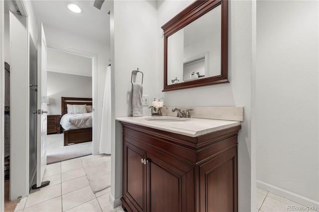 ensuite bathroom featuring tile patterned floors, baseboards, ensuite bathroom, and vanity