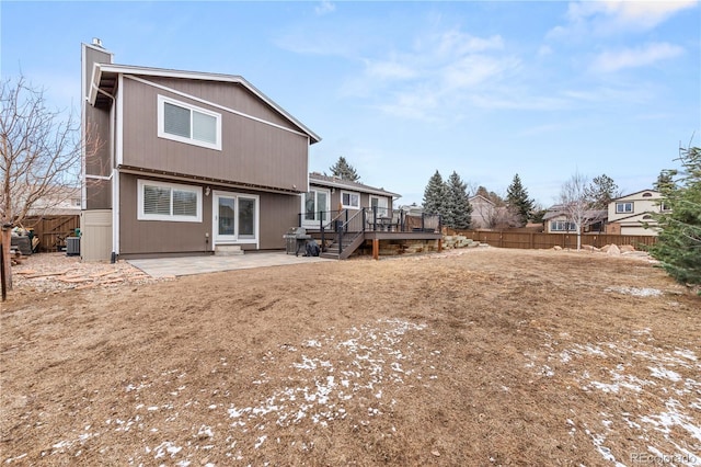 back of property featuring a patio area, fence, a chimney, and a wooden deck