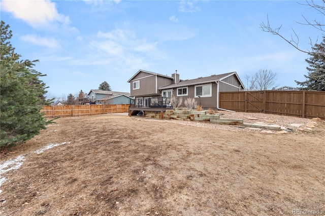 back of house with a fenced backyard and a deck