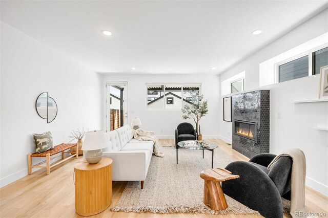 3658 Quivas St, Denver, CO 80211 - living area with a tile fireplace, recessed lighting, light wood-style floors, and baseboards