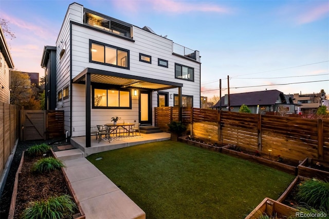 3658 Quivas St, Denver, CO 80211 - back of house at dusk with a gate and a patio area
