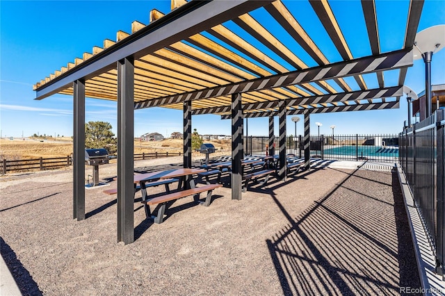 surrounding community featuring a pergola, a patio, and a rural view