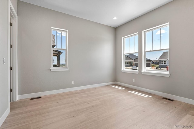 empty room with plenty of natural light and light wood-type flooring