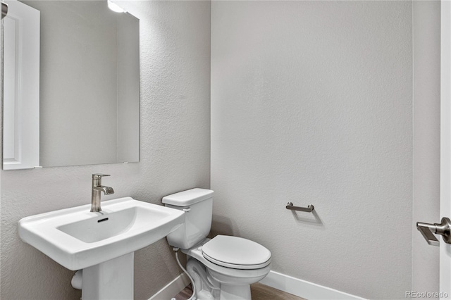 bathroom with sink, hardwood / wood-style flooring, and toilet