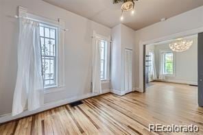 unfurnished room featuring an inviting chandelier and wood-type flooring