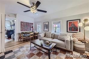 living room with ceiling fan and vaulted ceiling