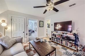 living room with ceiling fan and vaulted ceiling