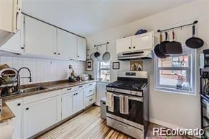 kitchen featuring sink, white cabinetry, stainless steel range with gas cooktop, and plenty of natural light