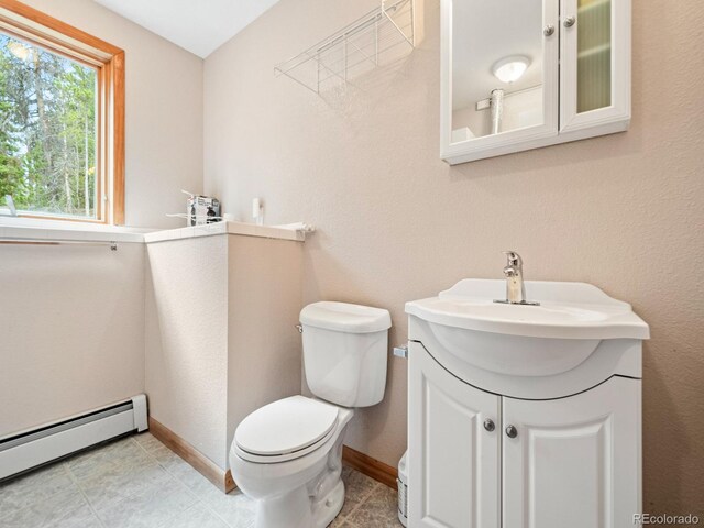 48 Warren Rd, Black Hawk, CO 80422 - half bathroom with toilet, baseboards, vanity, and a baseboard heating unit