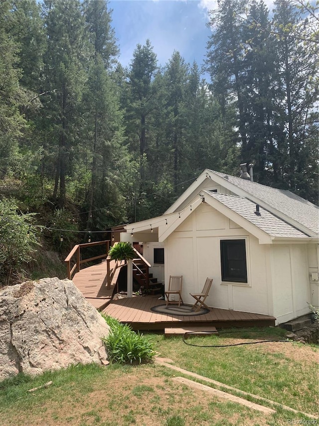 view of side of home with a lawn and a deck